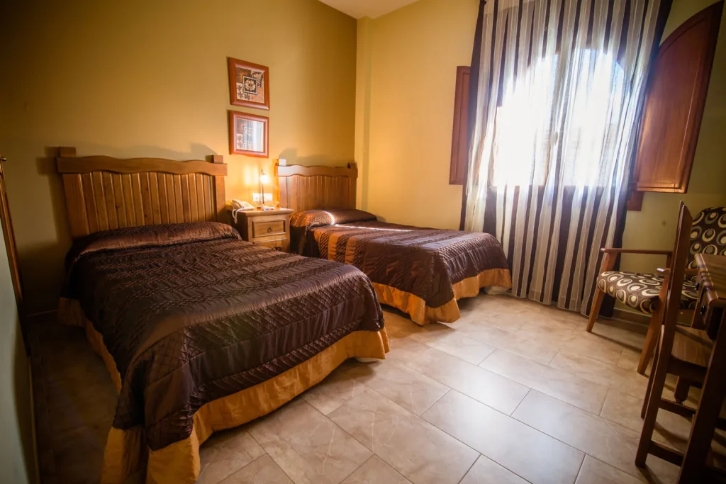 Habitación con dos camas y luz natural
